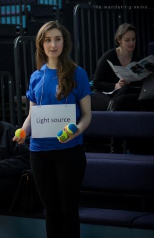 Helen demonstrating the nature of light with tennis balls at the Cambridge science festival